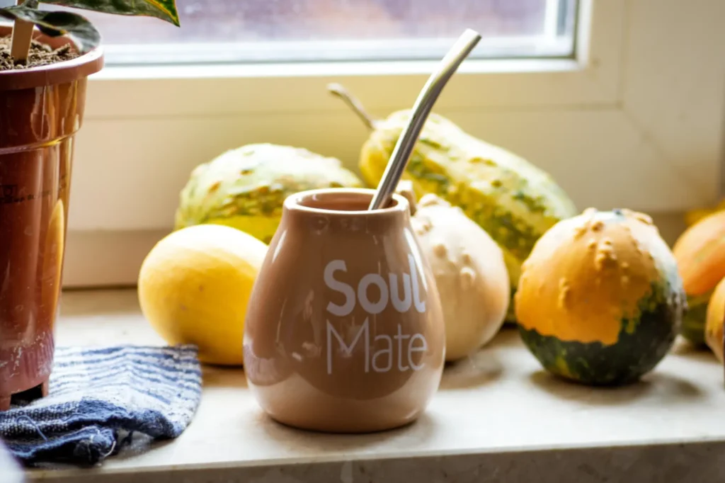 A cup sitting on a bench with a stainless steel straw in it