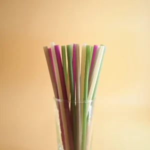 A glass cup filled with drinking straws